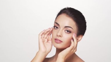 Beyaz arka planda genç ve güzel esmer bir kadının stüdyo portresi. Cilt bakımı ve sağlık kavramları.