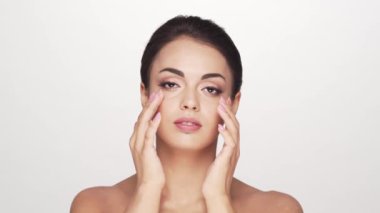 Beyaz arka planda genç ve güzel esmer bir kadının stüdyo portresi. Cilt bakımı ve sağlık kavramları.
