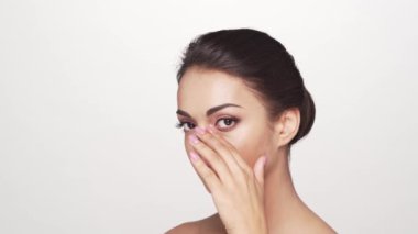 Beyaz arka planda genç ve güzel esmer bir kadının stüdyo portresi. Cilt bakımı ve sağlık kavramları.