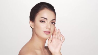 Beyaz arka planda genç ve güzel esmer bir kadının stüdyo portresi. Cilt bakımı ve sağlık kavramları.