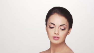 Beyaz arka planda genç ve güzel esmer bir kadının stüdyo portresi. Cilt bakımı ve sağlık kavramları.