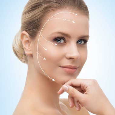 Yüzünde oklar olan genç, güzel ve sağlıklı bir kadın. Spa, ameliyat, yüz gerdirme ve makyaj konsepti