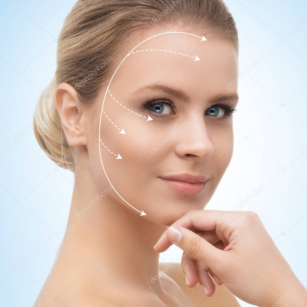 Young, beautiful and healthy woman with arrows on her face. Spa, surgery, face lifting and make-up concept