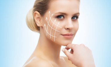Yüzünde oklar olan genç, güzel ve sağlıklı bir kadın. Spa, ameliyat, yüz gerdirme ve makyaj konsepti