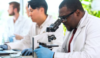 Laboratuvarda çalışan bir bilim adamı. Doktorlar tıbbi araştırma yapıyor. Laboratuvar aletleri: mikroskop, test tüpleri, ekipmanlar. Biyoteknoloji, kimya, bilim, deneyler ve sağlık konsepti. Gün ışığı ve