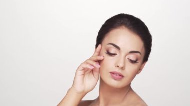 Beyaz arka planda genç ve güzel esmer bir kadının stüdyo portresi. Cilt bakımı ve sağlık kavramları.