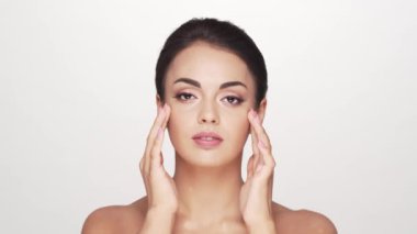 Beyaz arka planda genç ve güzel esmer bir kadının stüdyo portresi. Cilt bakımı ve sağlık kavramları.