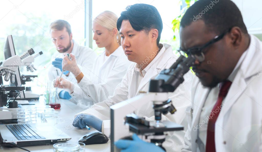 Scientist and students working in lab. Doctor teaching interns to make analyzing research. Laboratory tools: microscope, test tubes, equipment. Biotechnology, chemistry, bacteriology, virology, dna