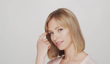 Genç, güzel ve doğal sarışın bir kadının stüdyo portresi. Yüz gerdirme, kozmetik ve makyaj konsepti.