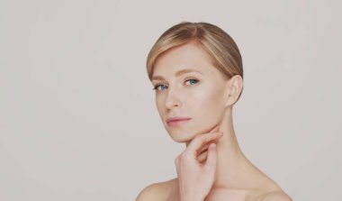 Genç, güzel ve doğal sarışın bir kadının stüdyo portresi. Yüz gerdirme, kozmetik ve makyaj konsepti.