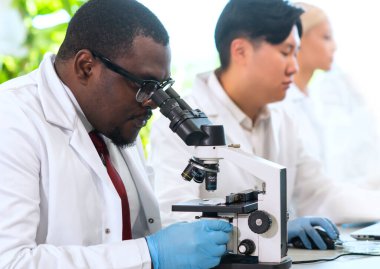 Laboratuvarda çalışan bilim adamları ve öğrenciler. Doktor stajyerlere araştırma yapmayı öğretiyor. Laboratuvar aletleri: mikroskop, test tüpleri, ekipmanlar. Biyoteknoloji, kimya, bakteriyoloji, viroloji, DNA