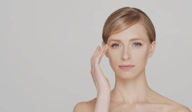 Genç, güzel ve doğal sarışın bir kadının stüdyo portresi. Yüz gerdirme, kozmetik ve makyaj konsepti.