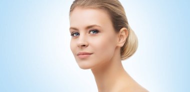 Mavi arka planda güzel bir kızın yüzü. Estetik cerrahi, cilt gerdirme, kaplıca, kozmetik ve tıp konsepti.