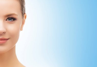 Mavi arka planda güzel bir kızın yüzü. Estetik cerrahi, cilt gerdirme, kaplıca, kozmetik ve tıp konsepti.