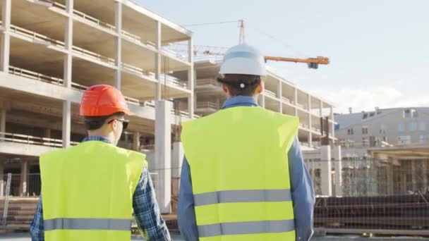 Professionele Bouwers Die Voor Bouwplaats Staan Voorman Civiel Ingenieur Hoeden — Stockvideo