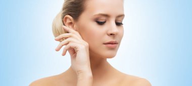 Mavi arka planda güzel bir kızın yüzü. Estetik cerrahi, cilt gerdirme, kaplıca, kozmetik ve tıp konsepti.