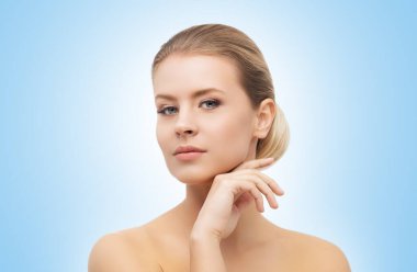 Mavi arka planda güzel bir kızın yüzü. Estetik cerrahi, cilt gerdirme, kaplıca, kozmetik ve tıp konsepti.