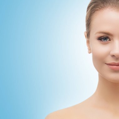 Mavi arka planda güzel bir kızın yüzü. Estetik cerrahi, cilt gerdirme, kaplıca, kozmetik ve tıp konsepti.
