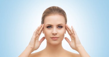 Mavi arka planda güzel bir kızın yüzü. Estetik cerrahi, cilt gerdirme, kaplıca, kozmetik ve tıp konsepti.