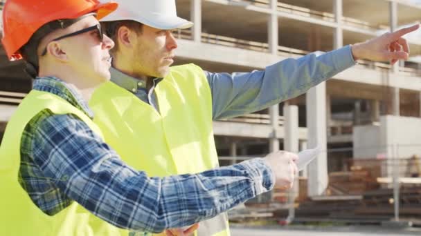 Professionele Bouwers Die Voor Bouwplaats Staan Voorman Civiel Ingenieur Hoeden — Stockvideo