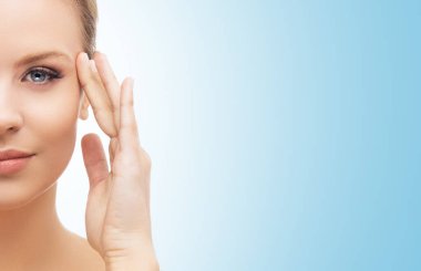 Mavi arka planda güzel bir kızın yüzü. Estetik cerrahi, cilt gerdirme, kaplıca, kozmetik ve tıp konsepti.