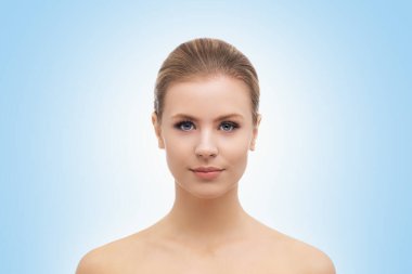 Mavi arka planda güzel bir kızın yüzü. Estetik cerrahi, cilt gerdirme, kaplıca, kozmetik ve tıp konsepti.