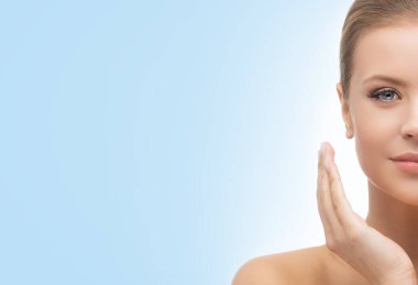 Mavi arka planda güzel bir kızın yüzü. Estetik cerrahi, cilt gerdirme, kaplıca, kozmetik ve tıp konsepti.