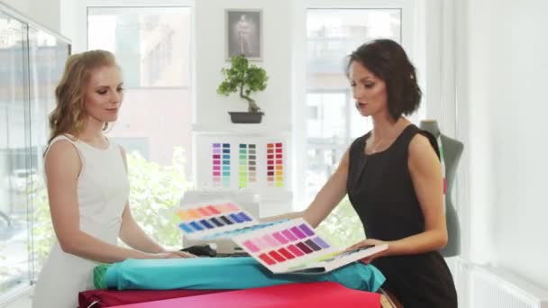 顾客和专业女裁缝在裁缝店里挑选面料 — 图库视频影像
