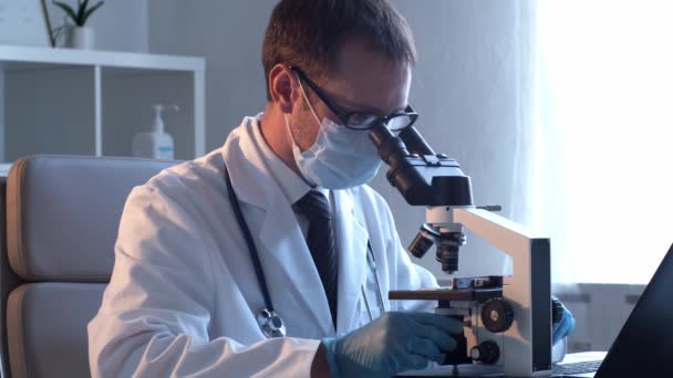 Profesionální lékař pracující v laboratoři pomocí mikroskopu. — Stock video