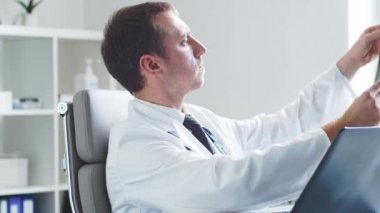 Hastane ofisinde çalışan profesyonel tıp doktoru bilgisayar teknolojisi kullanıyor. Tıp ve sağlık hizmetleri kavramları.