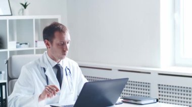 Hastane ofisinde çalışan profesyonel tıp doktoru bilgisayar teknolojisi kullanıyor. Tıp ve sağlık hizmetleri kavramları.