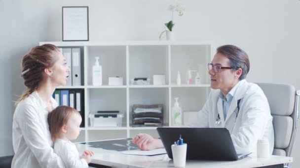 Pediatr zkoumá nemocné děťátko. Doktor, matka a dcera na klinice.. — Stock video