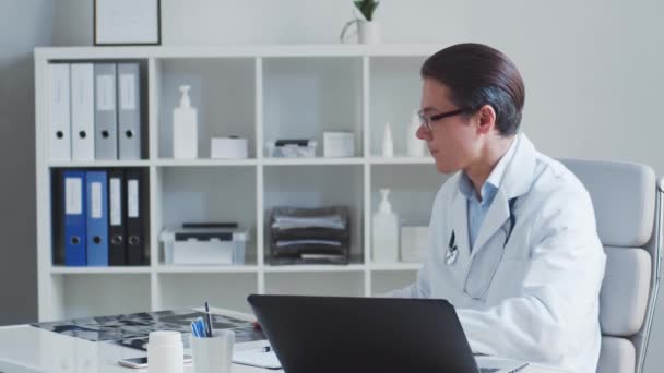 Médico profesional que trabaja en la oficina del hospital utilizando tecnología informática. — Vídeo de stock