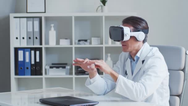 Médico profissional que trabalha em consultório hospitalar usando tecnologia de realidade virtual. — Vídeo de Stock