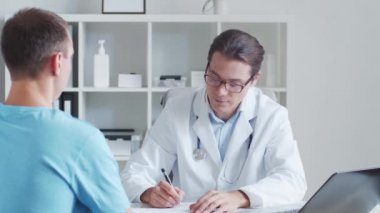 Erkek çocuk doktoru genç bir adamı muayene ediyor. Klinikteki doktor ve hasta. Sağlık hizmetleri kavramı.