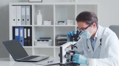 Mikroskop kullanarak laboratuvarda çalışan profesyonel tıp doktoru. Bilim ve sağlık kavramları.