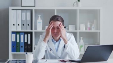 Hastane ofisinde çalışan yorgun ve stresli bir doktor. Tıp ve sağlık hizmetleri kavramları.