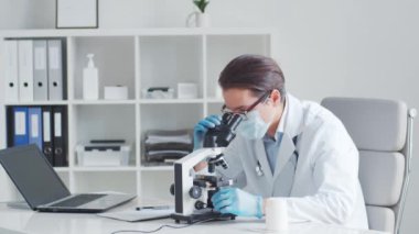 Mikroskop kullanarak laboratuvarda çalışan profesyonel tıp doktoru. Bilim ve sağlık kavramları.