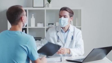 Erkek çocuk doktoru genç bir adamı muayene ediyor. Klinikteki doktor ve hasta. Sağlık hizmetleri kavramı.