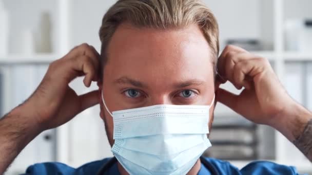 Médico profesional que trabaja en la oficina del hospital, Retrato de médico joven y confiado en máscara protectora. — Vídeo de stock