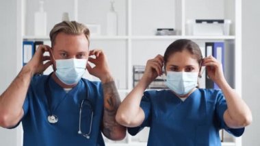 Hastane ofisinde çalışan profesyonel tıp doktorları koruyucu maskeli genç ve kendinden emin doktorların portresi..
