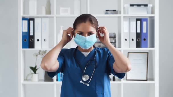 Médecin professionnel travaillant dans le bureau de l'hôpital, Portrait de jeune et séduisante femme médecin en masque de protection. — Video