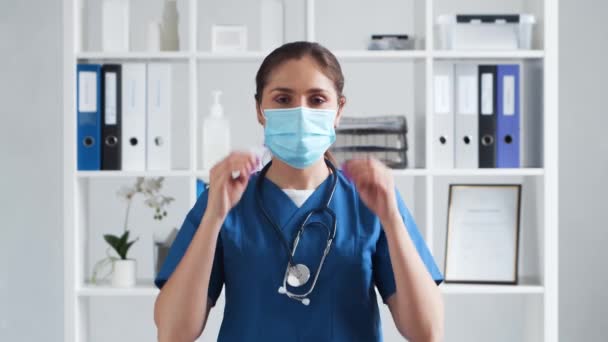 Professionele arts werkzaam in het ziekenhuis kantoor, Portret van jonge en aantrekkelijke vrouwelijke arts met beschermend masker. — Stockvideo