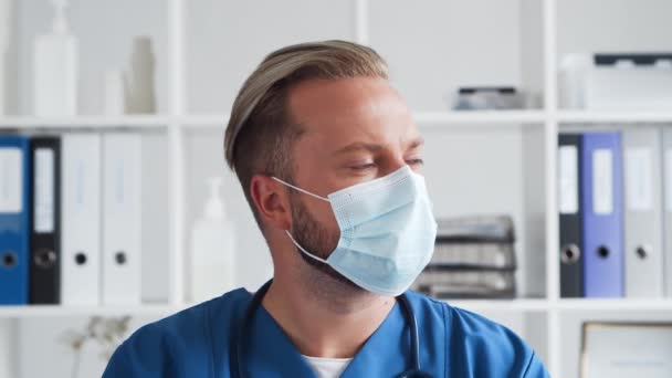 Médico profesional en consultorio hospitalario, Retrato de médico joven y confiado en máscara protectora. — Vídeo de stock