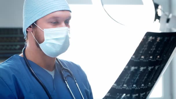 A hivatásos orvos a sürgősségi orvosláson dolgozik. A beteg röntgenfelvételét ellenőrző sebész. — Stock videók