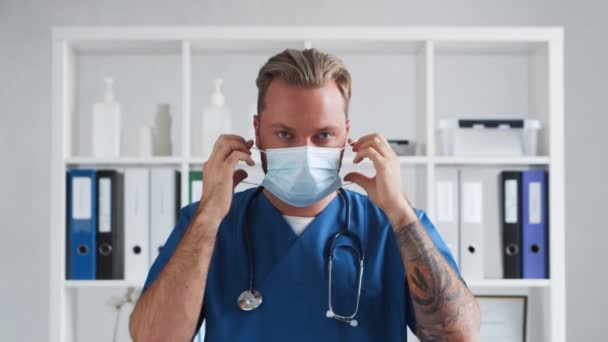 병원 사무실의 전문 의사, 보호용 마스크를 쓰고 있는 젊고 자신감 있는 의사의 초상. — 비디오