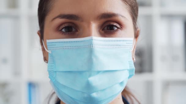 Professionele arts in het ziekenhuis kantoor, Portret van jonge en aantrekkelijke vrouwelijke arts met beschermend masker. — Stockvideo