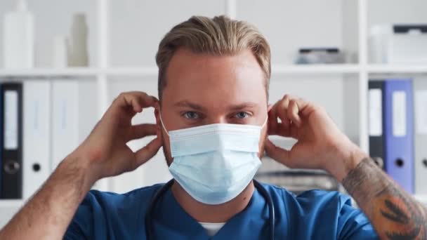 Professzionális orvos dolgozik kórházi irodában, portré fiatal és magabiztos orvos védő maszk. — Stock videók