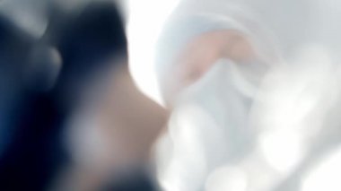 Doktorların elindeki oksijen maskesinin birinci şahıs görüntüsü. Hasta koruyucu maskeli cerrahın yüzüne bakıyor. Anestezi ve narkoz kavramları.