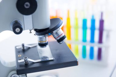 Laboratuvarda renkli bir test tüpüyle mikroskobun yakın çekimini yap.